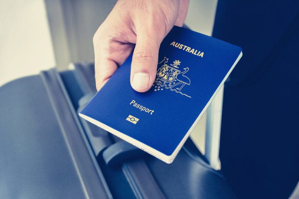 Australian passport held above luggage